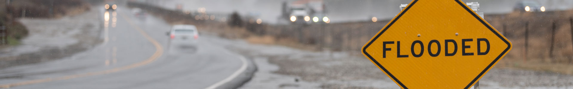 flooded street with Flooded sign in the forefront